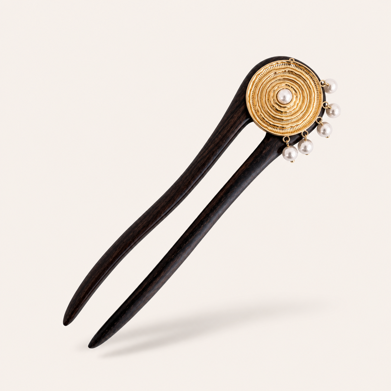 Decorative hair comb with gold circular design and pearls on a white background