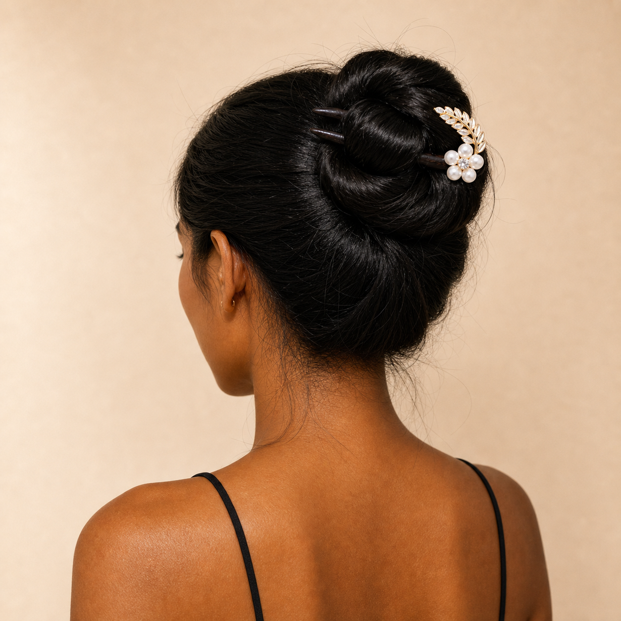 Woman with styled hair featuring a decorative hairpin against a beige background