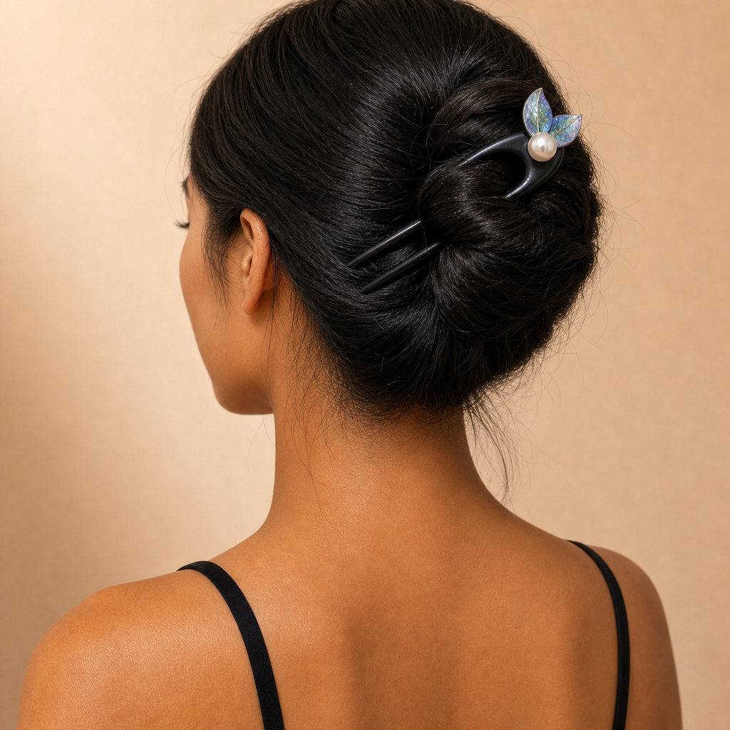 Rear view of a high bun secured firmly with a 14cm fishtail ebony hair fork on medium thickness long hair.